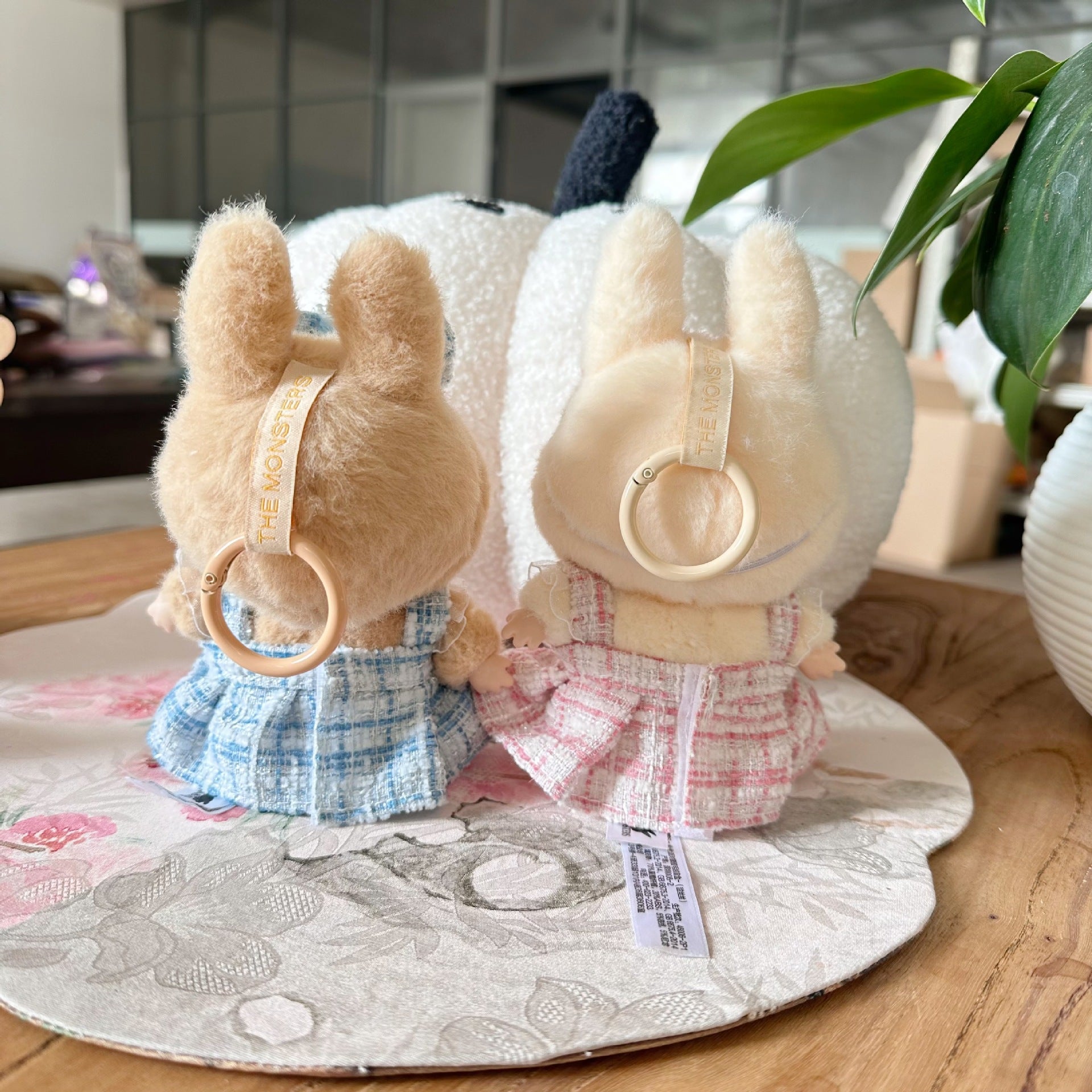 Two plush toys with headbands on a decorative plate indoors