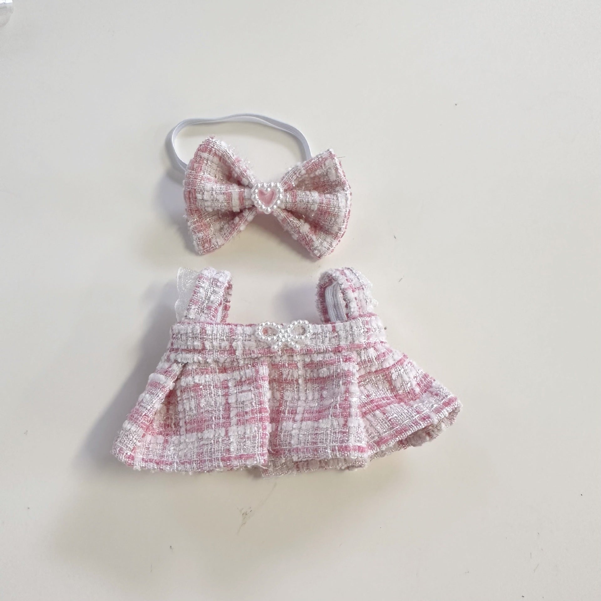 Baby dress and headband set with pink and white checkered pattern on a light background