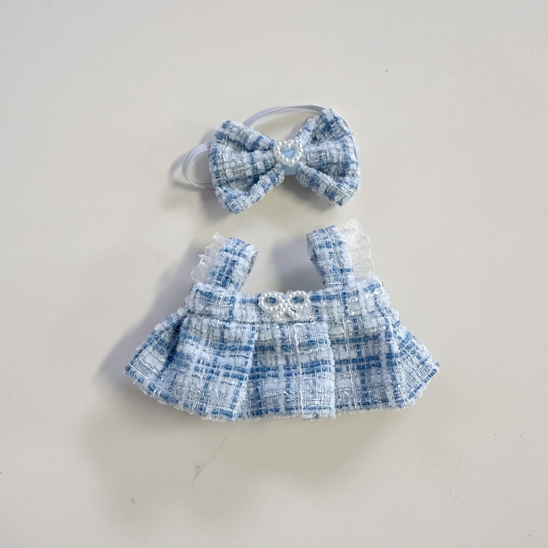 Blue checkered dress with matching headband on a light gray background