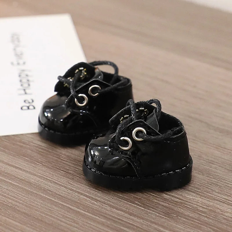 Pair of black shoes with decorative laces on a wooden surface