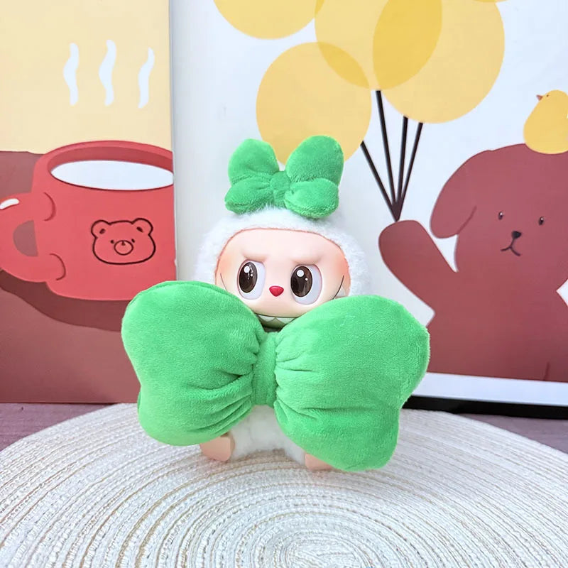 Plush toy with a green bow on a textured surface with a colorful background
