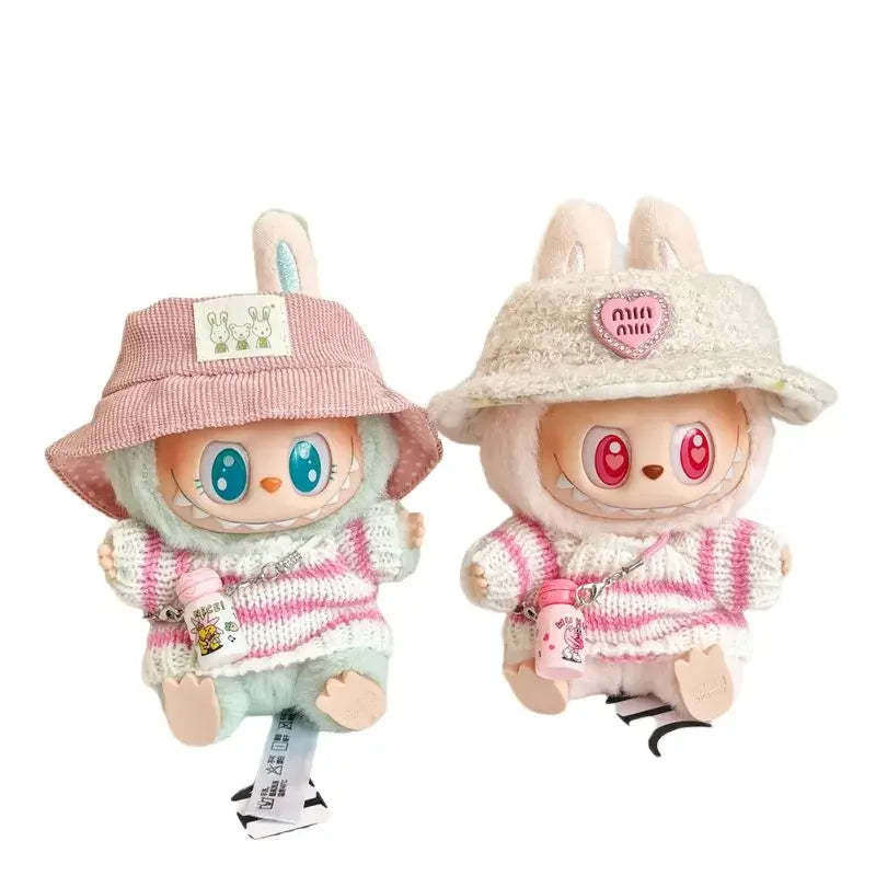 Two plush toys with colorful eyes and cute outfits on a white background