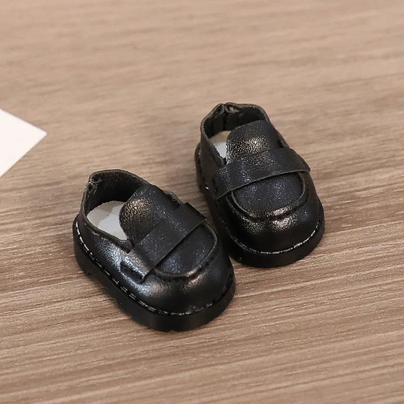 Pair of black leather shoes on a wooden surface