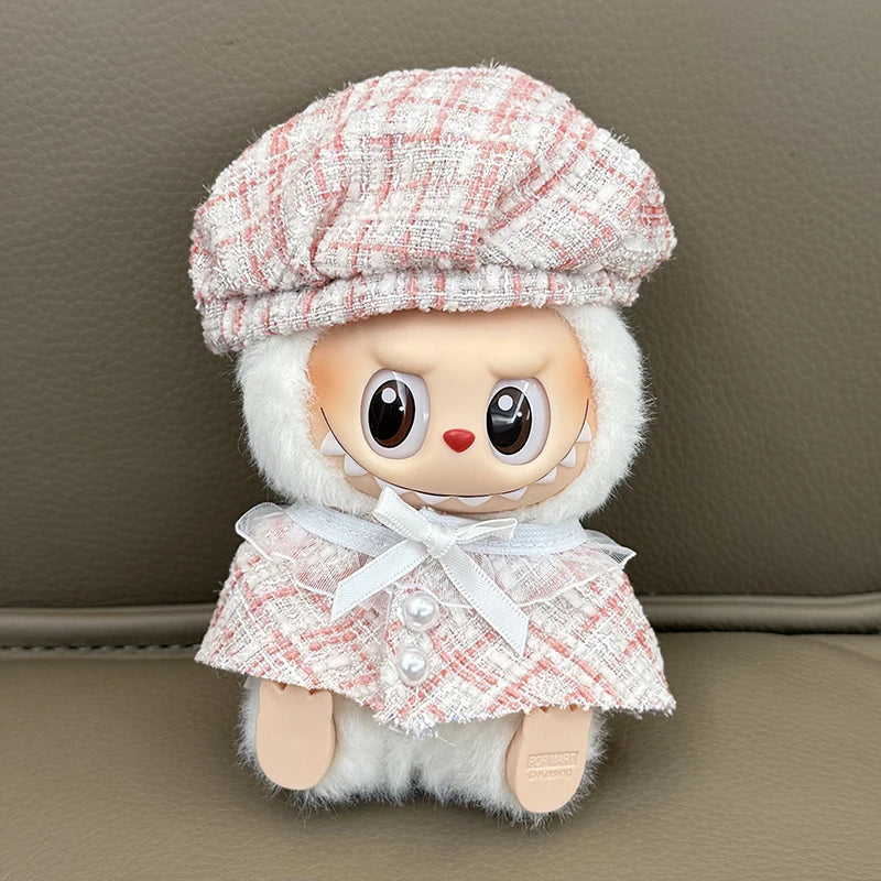 Stuffed toy with a plaid hat and coat on a neutral background