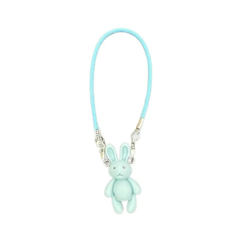 Light blue bunny charm on a cord against a white background