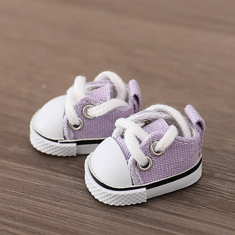 Pair of purple and white baby sneakers on a wooden surface