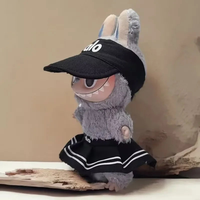 Plush toy with a black cap and black outfit on a wooden surface