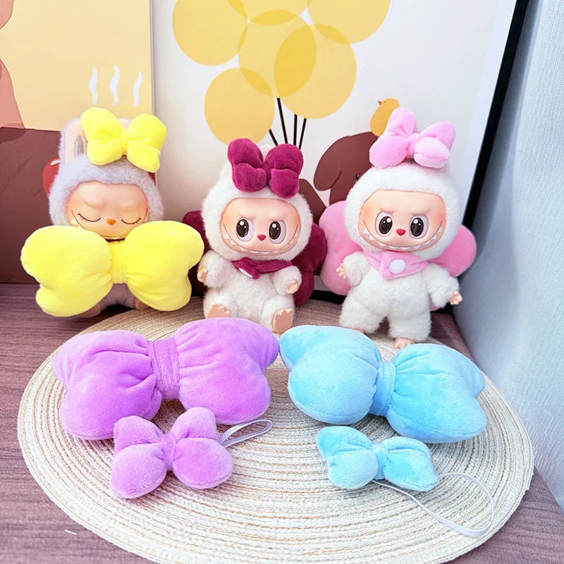 Three plush toys with colorful bows on a textured surface with decorative elements in the background.
