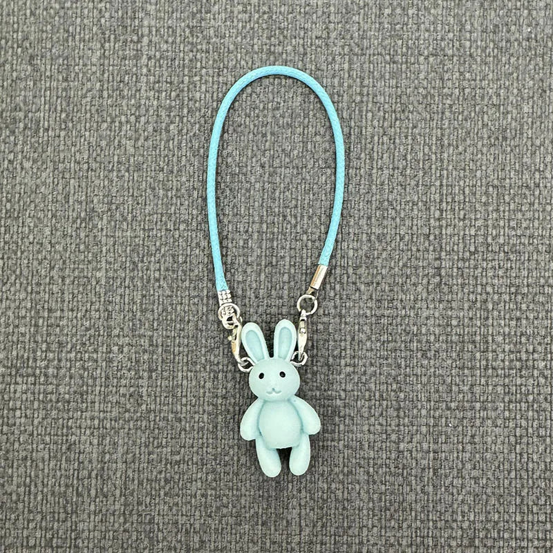 Light blue bunny keychain on a gray textured background