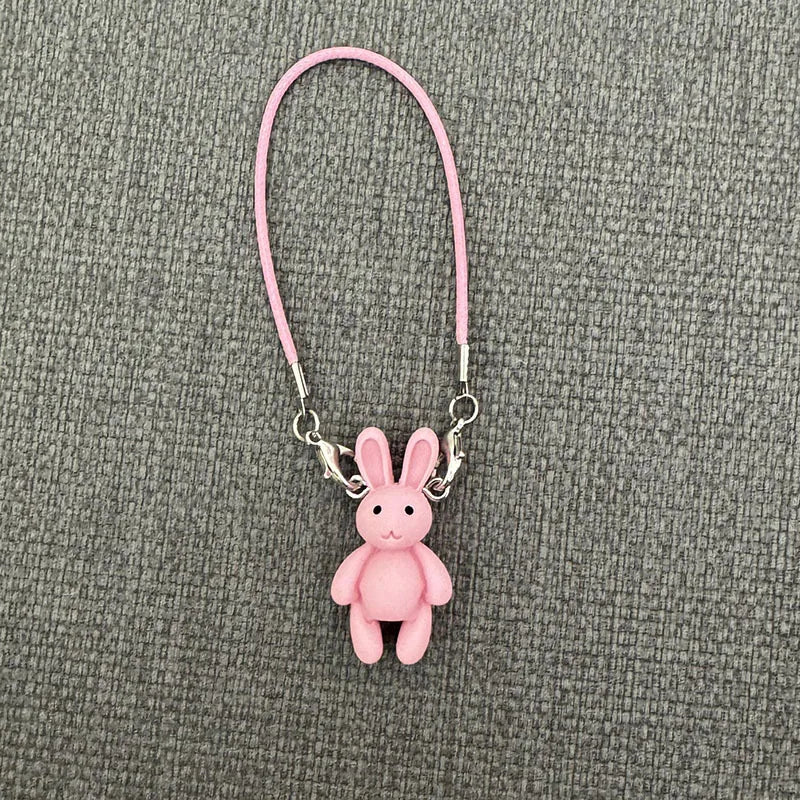 Pink bunny keychain on a gray textured background
