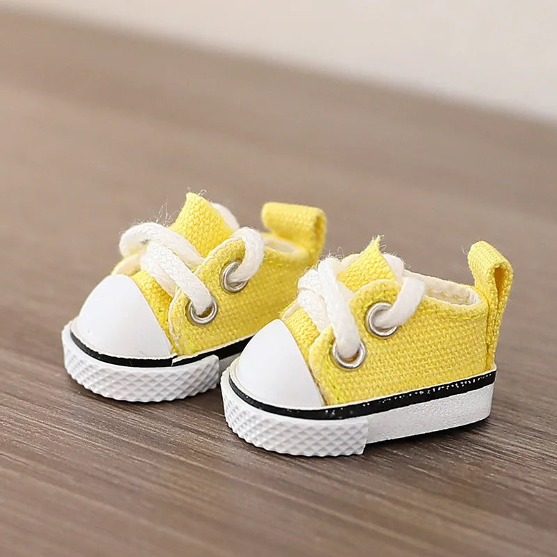 Pair of yellow baby sneakers with white soles on a wooden surface