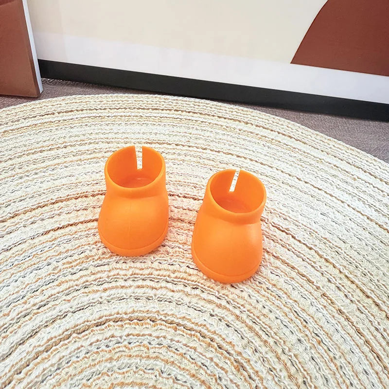 Two orange candle holders on a textured rug