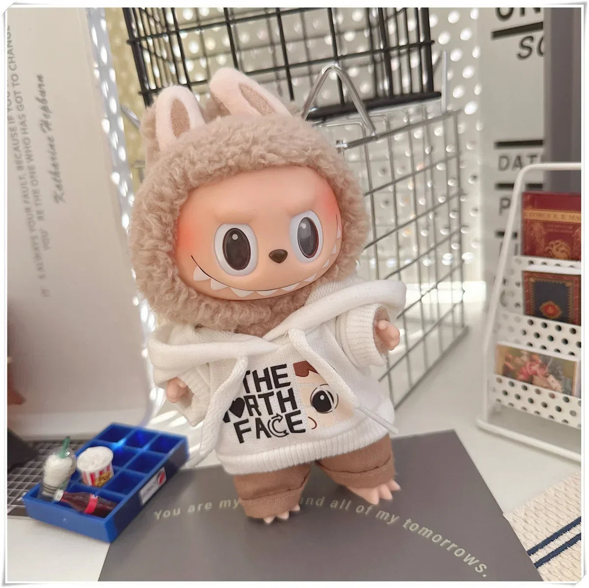 Plush toy in a costume holding a 'The North Face' bag in a room setting.
