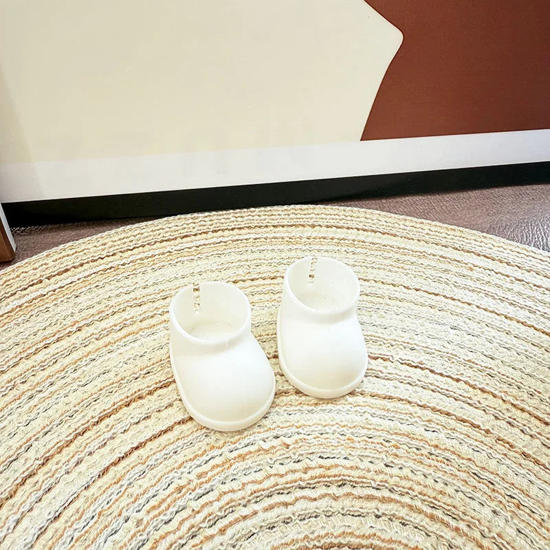 Two white shoes on a round woven rug with a neutral wall background