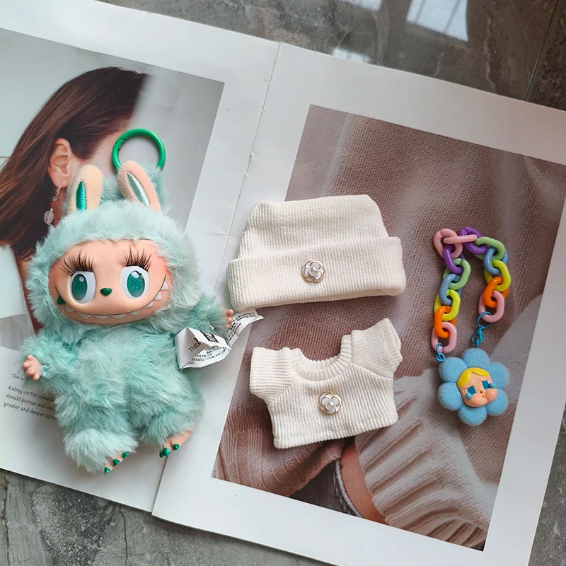 Toy with green fur and bunny ears, white outfit, and colorful teething toy on a magazine.