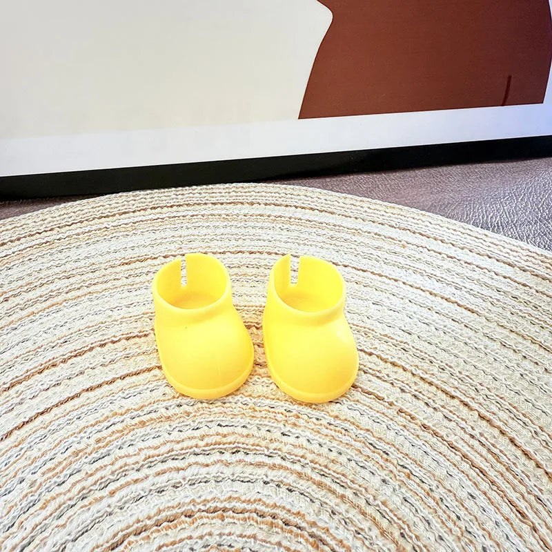 Pair of yellow baby shoes on a textured rug