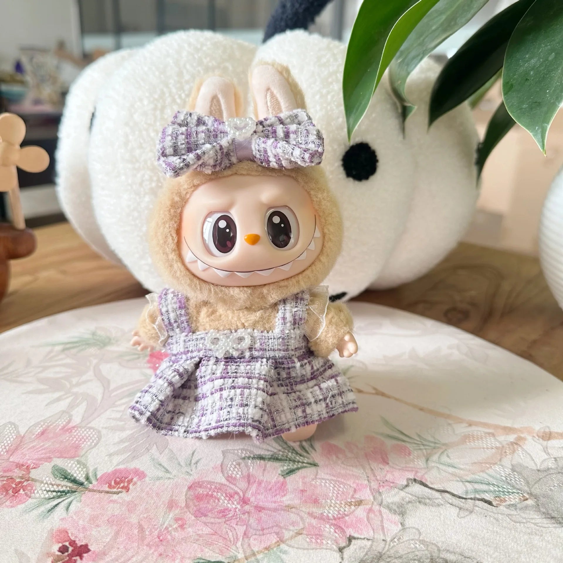 Plush toy with a bow and dress on a floral surface