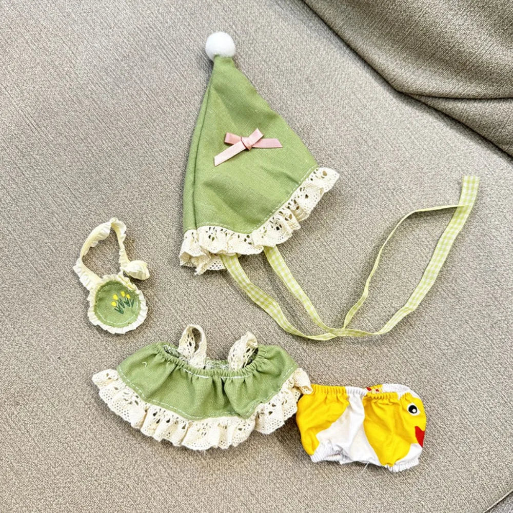 Set of green baby outfit with hat, bib, and diaper on a textured surface
