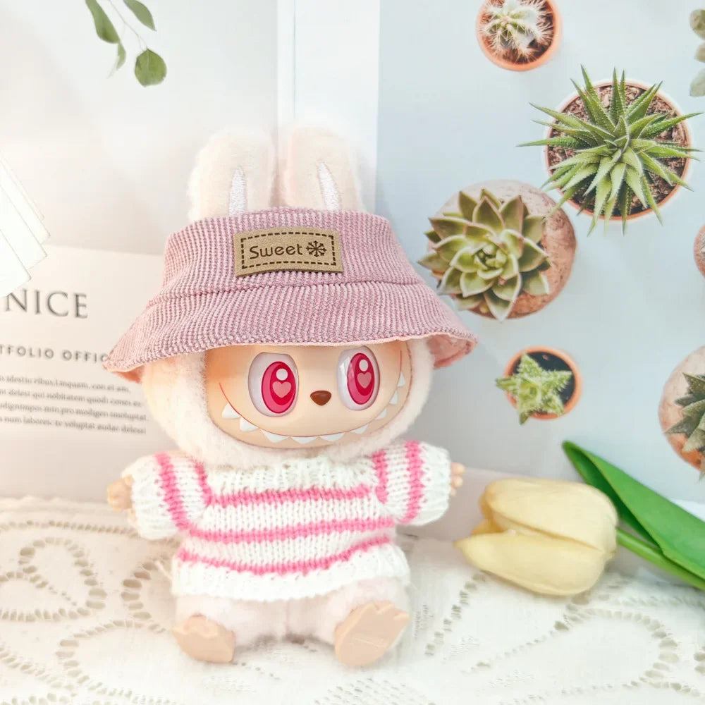 Toy figure with a pink hat and striped shirt on a decorative surface with plants.