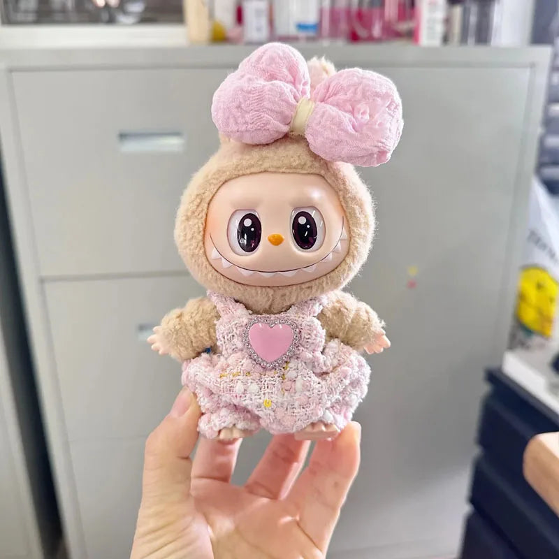 Plush toy with a pink bow held by a hand in an indoor setting