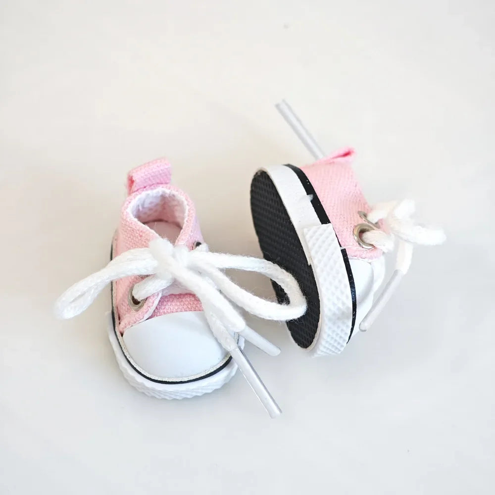 Pair of pink and white baby sneakers on a light background