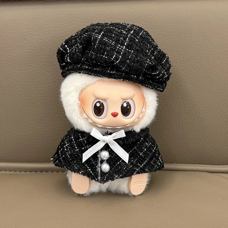 Stuffed toy with a black outfit and hat on a beige background