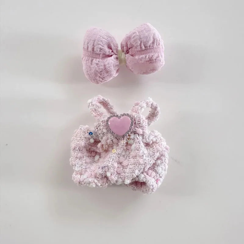 Pink bunny headband with heart detail and matching bow on a light gray background