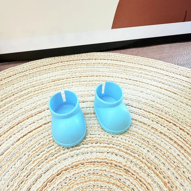 Two blue silicone boot-shaped candles on a textured surface.