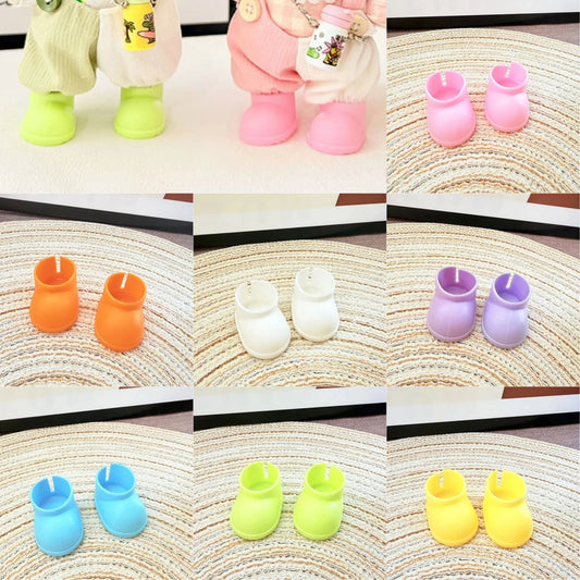Collage of colorful baby bootie-shaped candles on a textured surface.