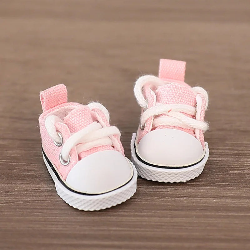 Pair of pink and white baby shoes on a wooden surface