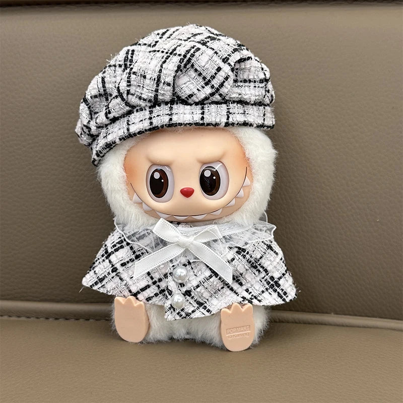 Stuffed toy with a black and white checkered hat and coat on a beige background
