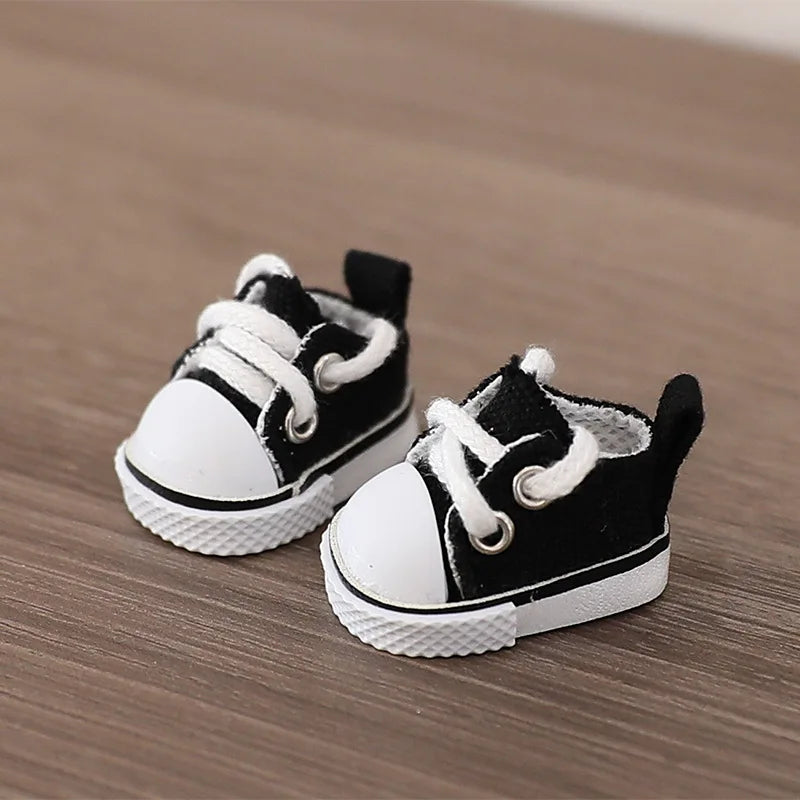Pair of black and white baby sneakers on a wooden surface