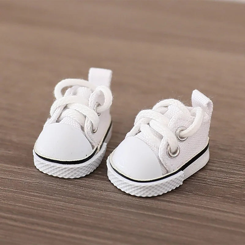 Pair of white baby sneakers on a wooden surface