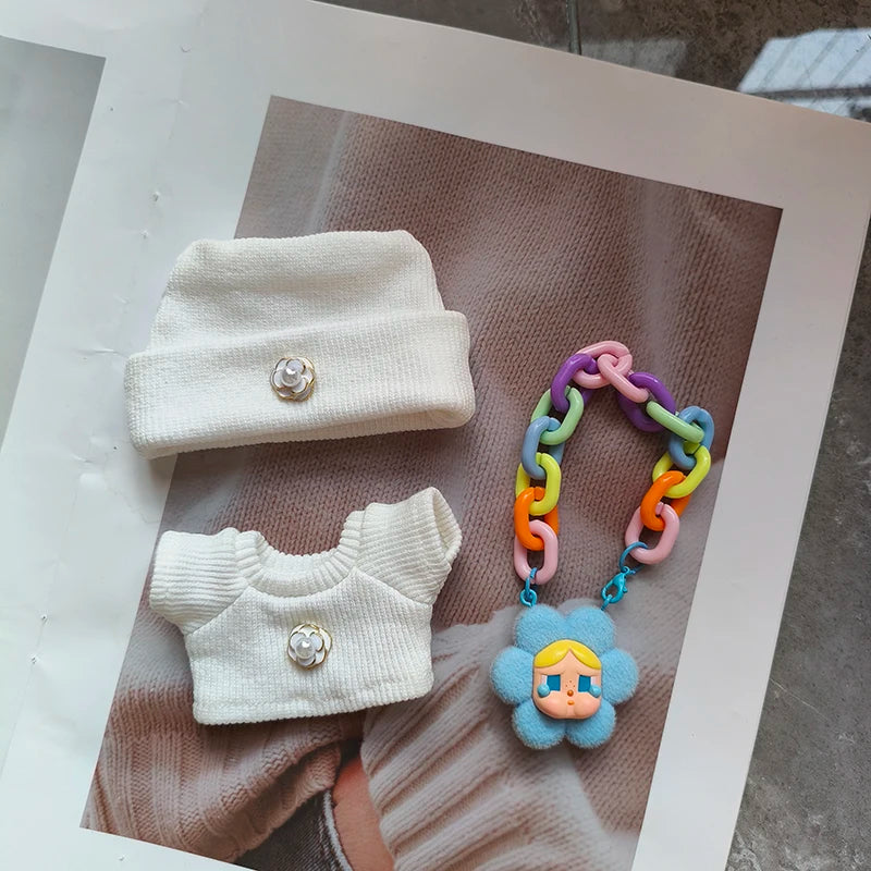 White baby outfit with colorful teething toy on a textured surface