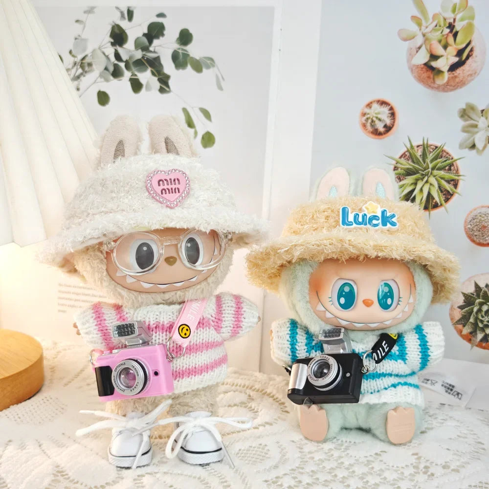 Two plush toys with hats and cameras on a decorative background with plants.