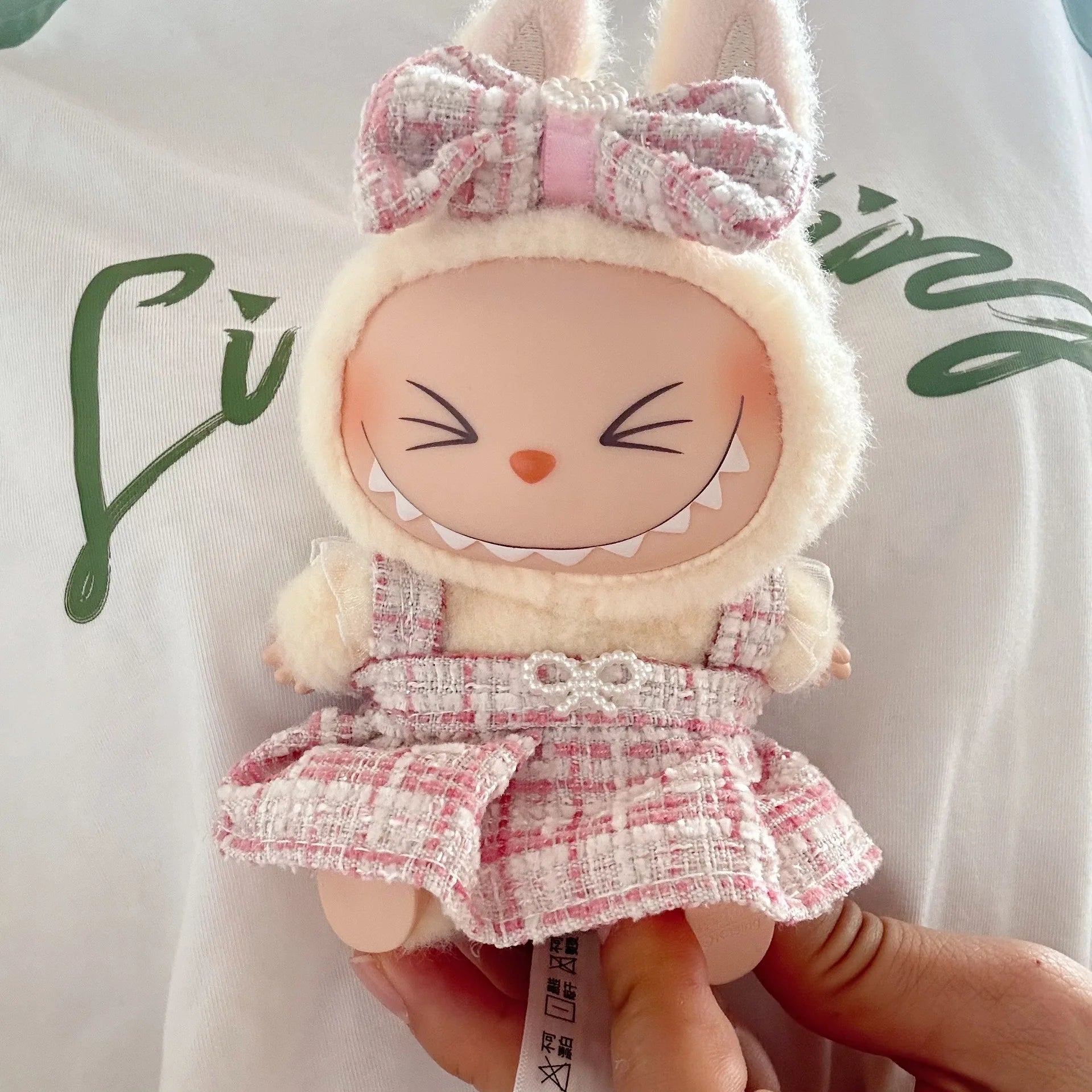 Plush toy with a bunny costume and pink bow on a white background