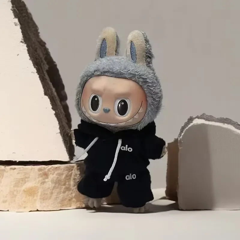 Plush toy with a gray hood and black outfit on a textured surface