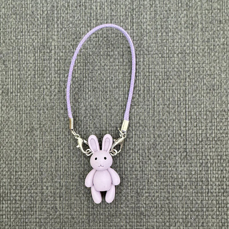 Purple bunny keychain on a textured gray background
