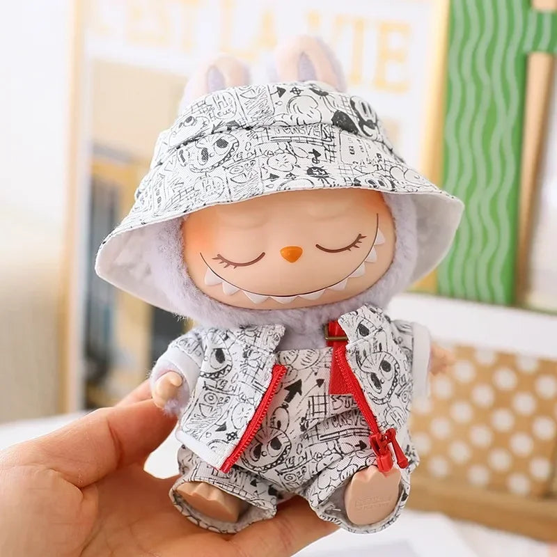 Stuffed toy with a black and white patterned hat and outfit, held in a hand.
