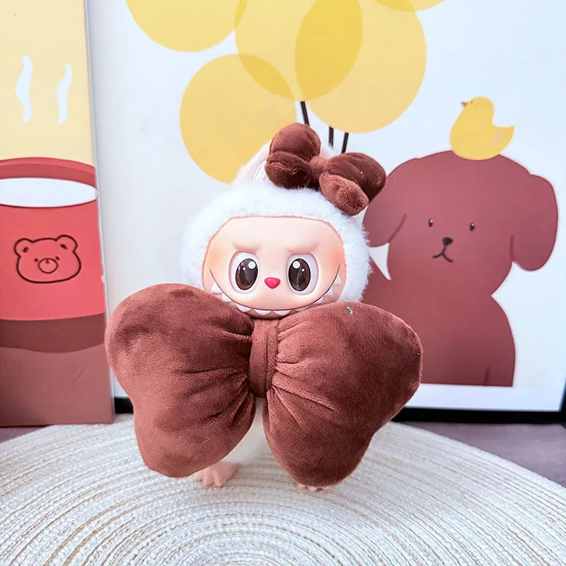 Plush toy with a large brown bow in front of a cartoon bear and balloons on a white wall.