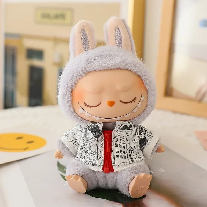 Plush toy with a gray hood and black and white jacket on a light surface.