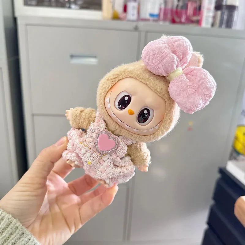 Plush toy with a pink bow held by a hand in a kitchen setting