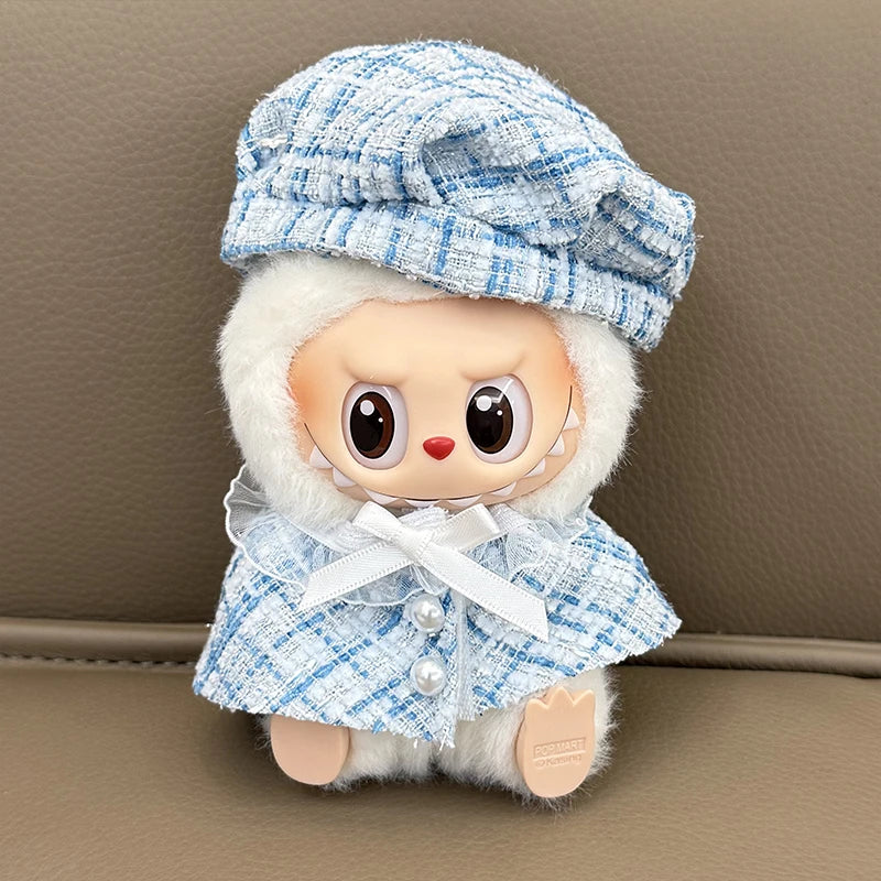 Stuffed toy with a blue checkered hat and coat on a brown surface