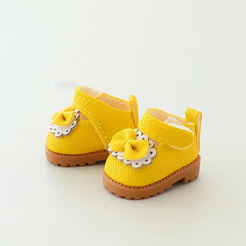 Yellow baby shoes with brown soles on a light background