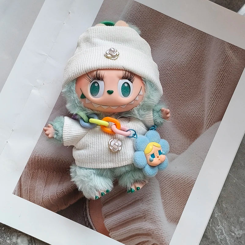Toy figure with a white hat and colorful scarf, holding a small toy, on a textured surface.
