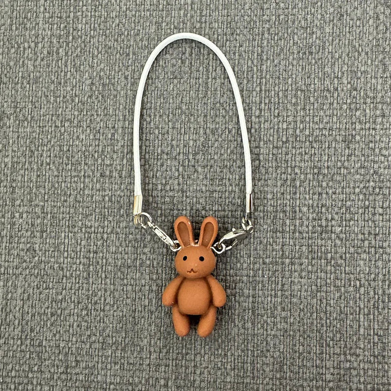 Brown bunny keychain on a gray textured background