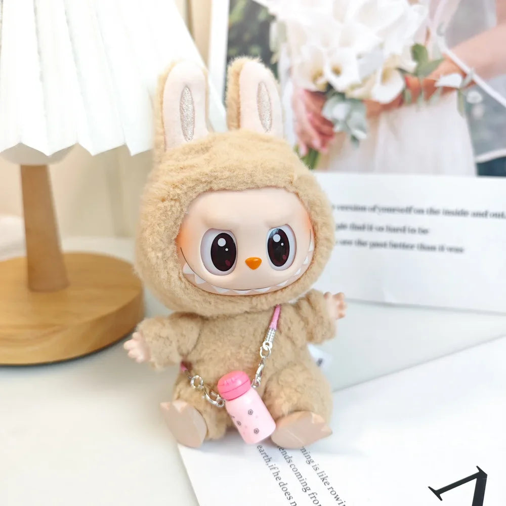 Plush toy with bunny ears and a pink bottle charm on a blurred background