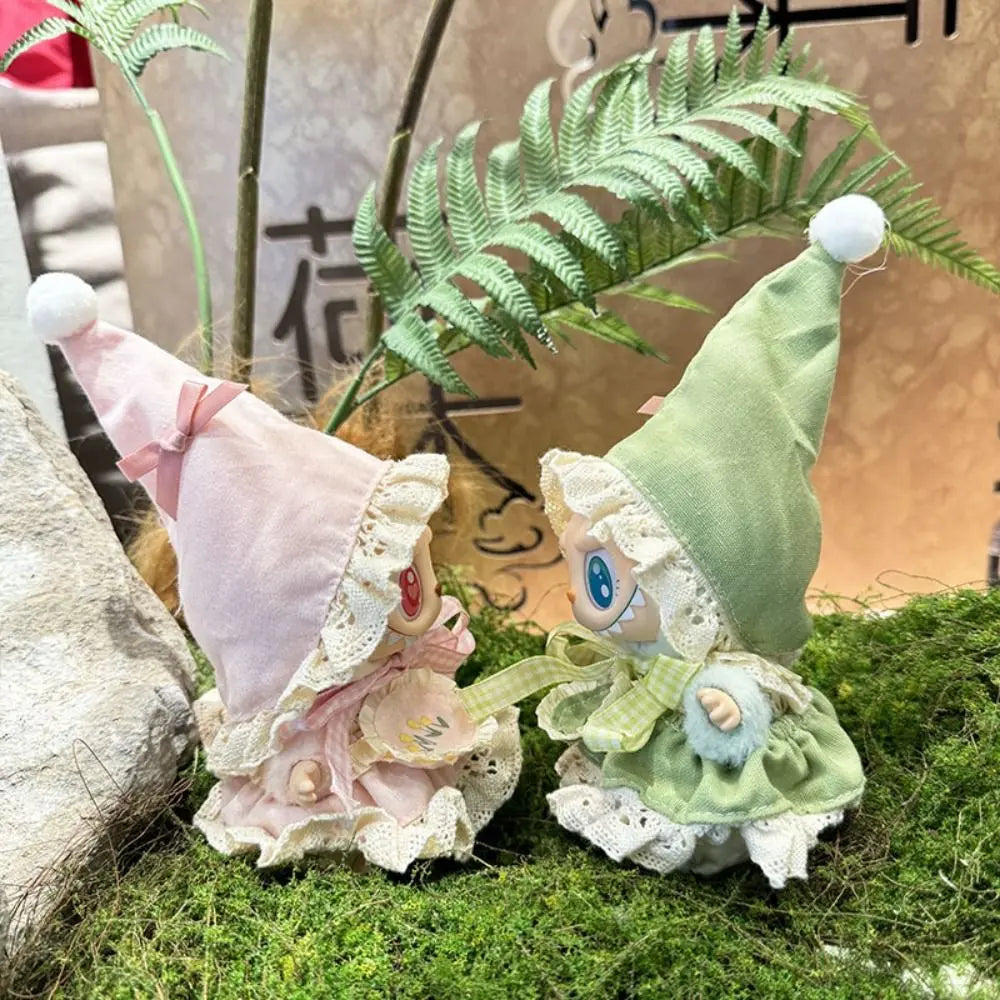 Two small fairy-like figures with colorful hats on a grassy surface.