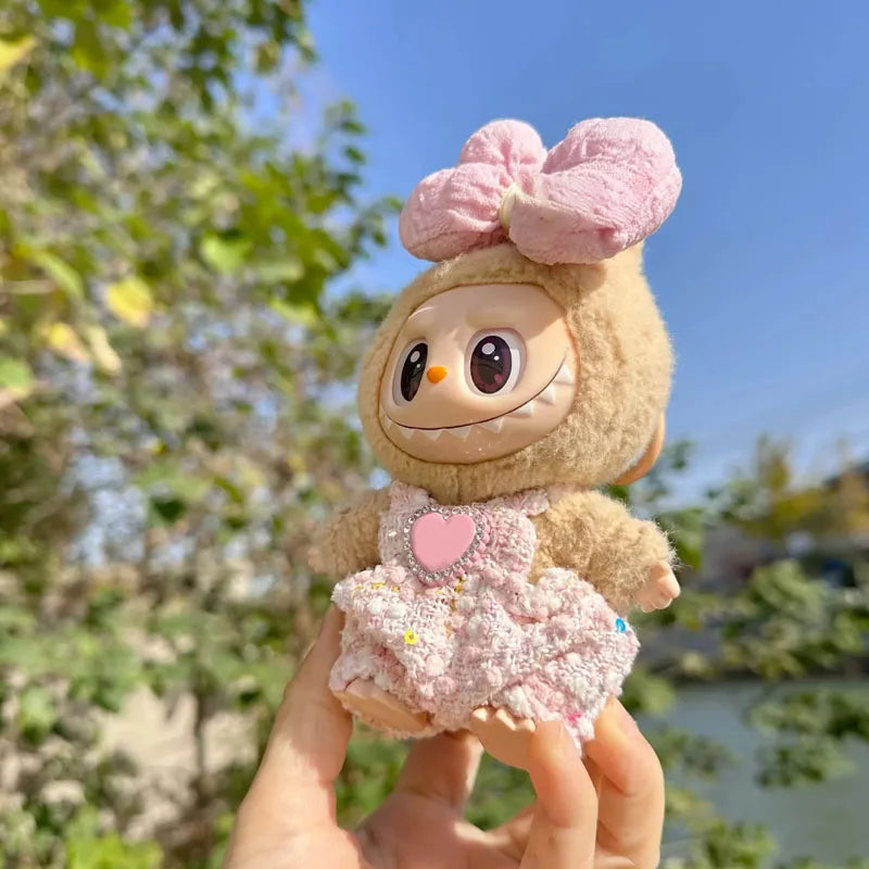 Plush toy with a pink bow held in front of a blurred natural background