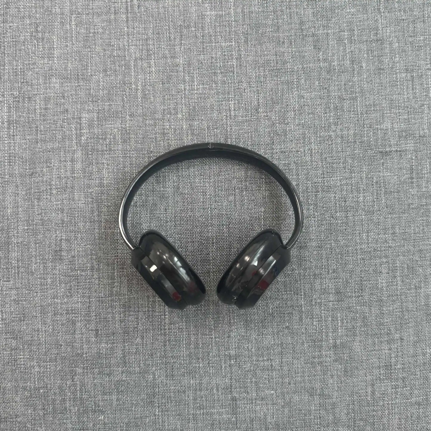 Black wireless earbuds on a gray textured surface